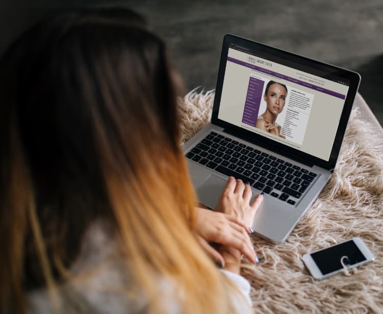 Woman sitting in bed using laptop