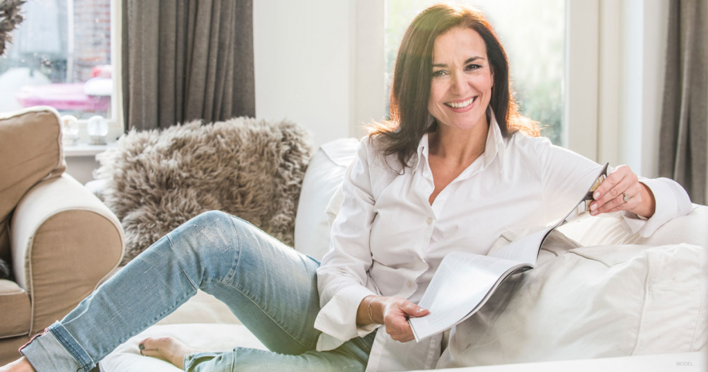 Women sitting on couch reading newspaper