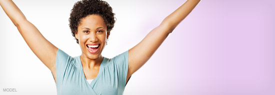 Woman with arms raised over her head showing victory.