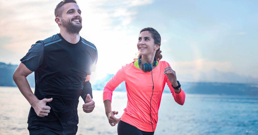 Man and woman jogging along the shore