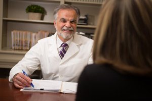 Dr. Petrosky sitting across his desk from a patient