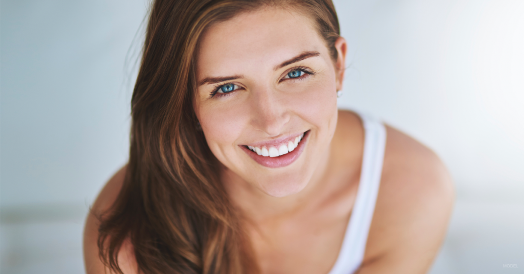 Smiling young woman with dark hair and blue eyes