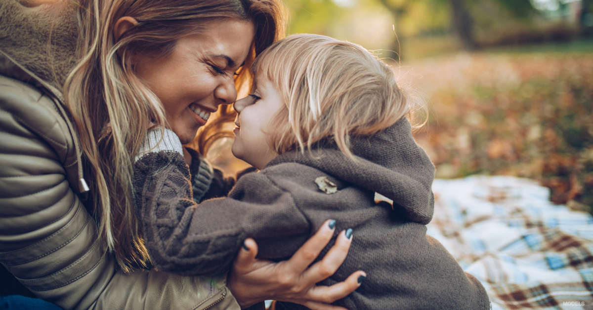 Young woman rubbing noses with young child