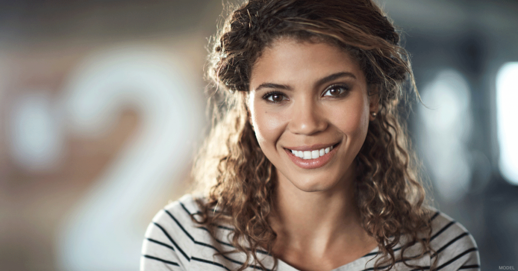 Young woman smiling and wearing a white shirt with black stripes