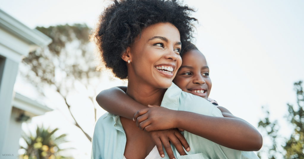 Mother in Atlanta, GA giving son a piggyback ride (models)